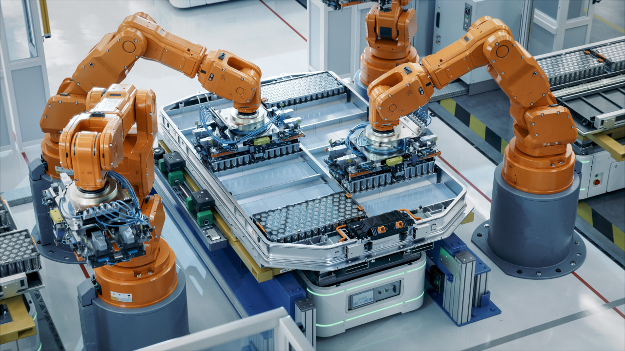 Elektrische Autofabrik mit Roboterwaffen. Installation des Akkumoduls und Produktion mit Seltenen Erden