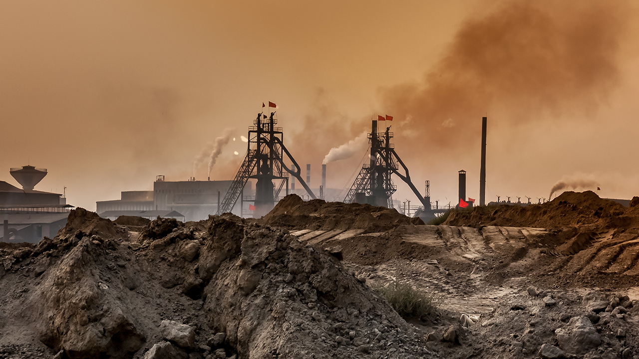 Eine Industrieanlage, die rohstoffe und seltene erden fördert und verarbeitet, mit Rauchschwaden am Himmel.