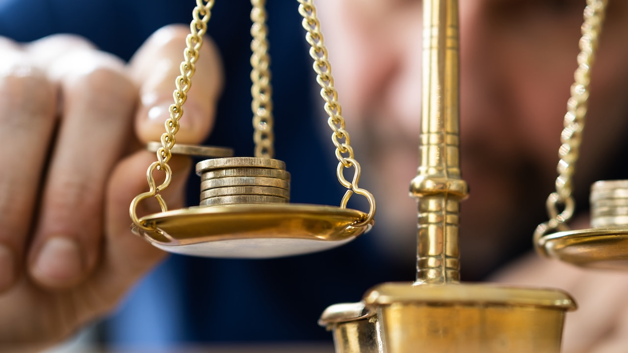 Lawyer using scale to compare economy, gold and money
