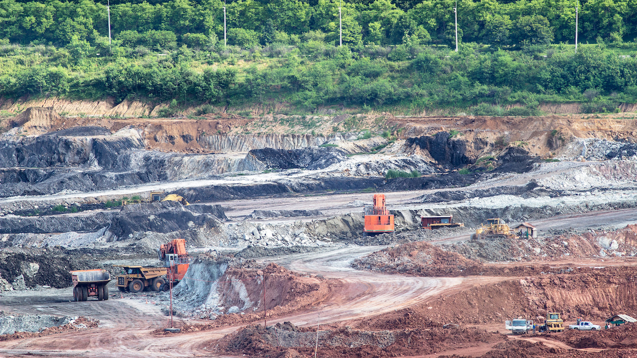 Lastfahrzeuge im offenen Minengelände für den Abbau Seltener Erden in China