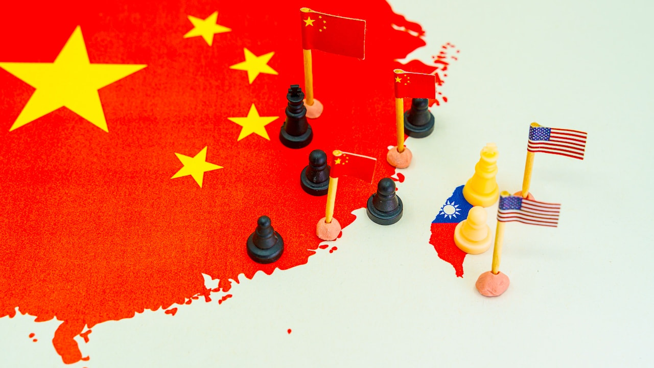 Weltkarte mit Taiwan, China und USA-Flaggen an der Grenze als Illustration steigender Spannungen und des Konfliktkonzepts