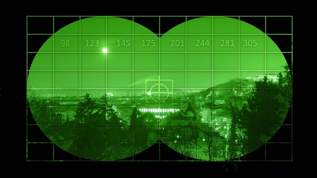 Blick durch ein Nachtsichtgerät auf ein Industriegebiet