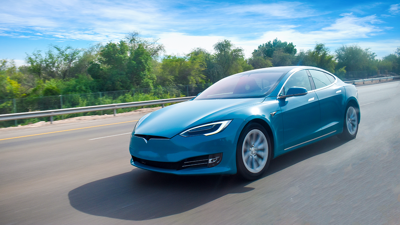 Ein Elektroauto auf der Autobahn, blauer Himmel und schönes Klima