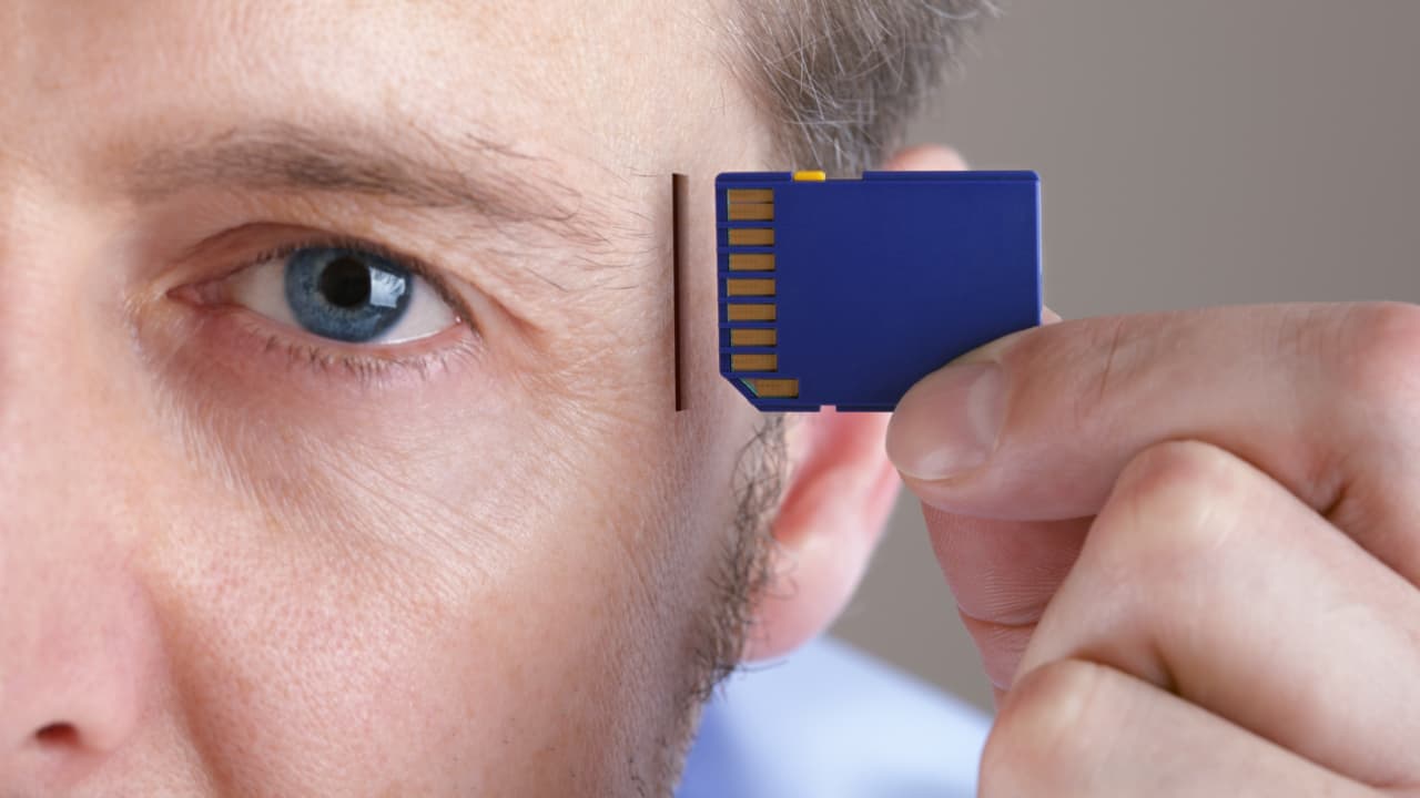Einstecken einer SD-Speicherkarte in einen Steckplatz im menschlichen Kopfkonzept für Speicheraufrüstung, Vergesslichkeit oder Computing